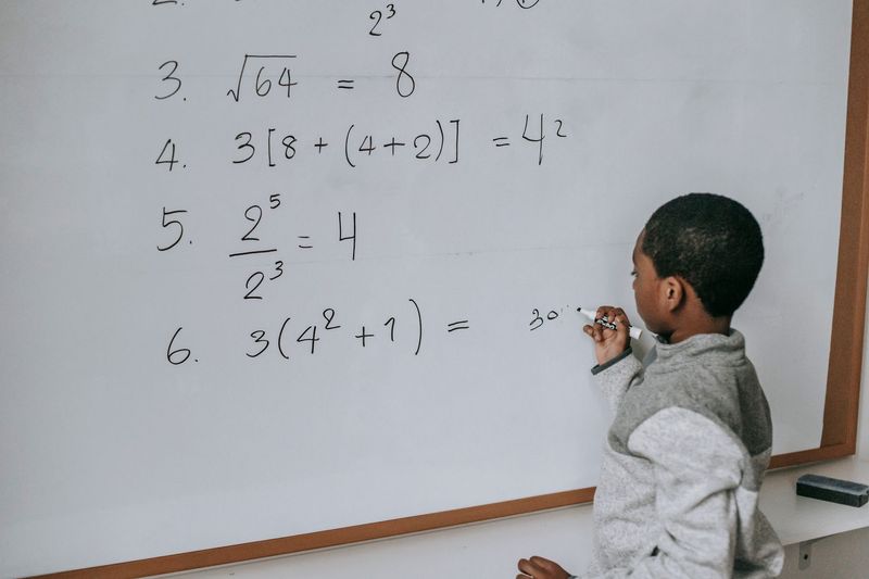 Mathematics tutor explaining algebra on a digital whiteboard during an online lesson