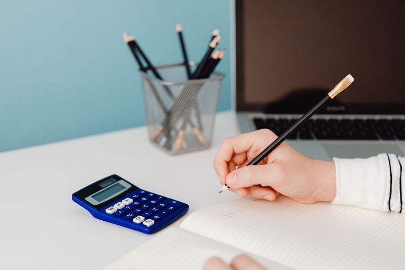 High school Physical Science study materials, calculator and laboratory notes arranged on a desk