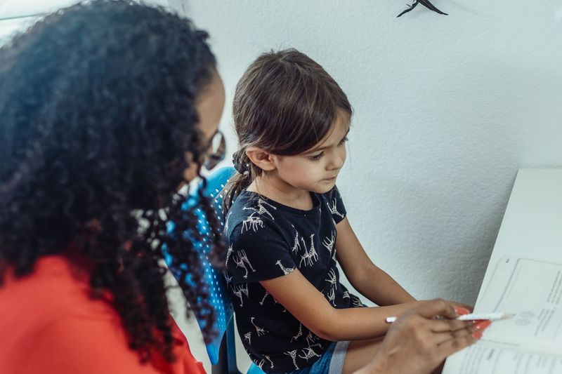 a friendly tutor working one-on-one with a student on mathematics or physical science